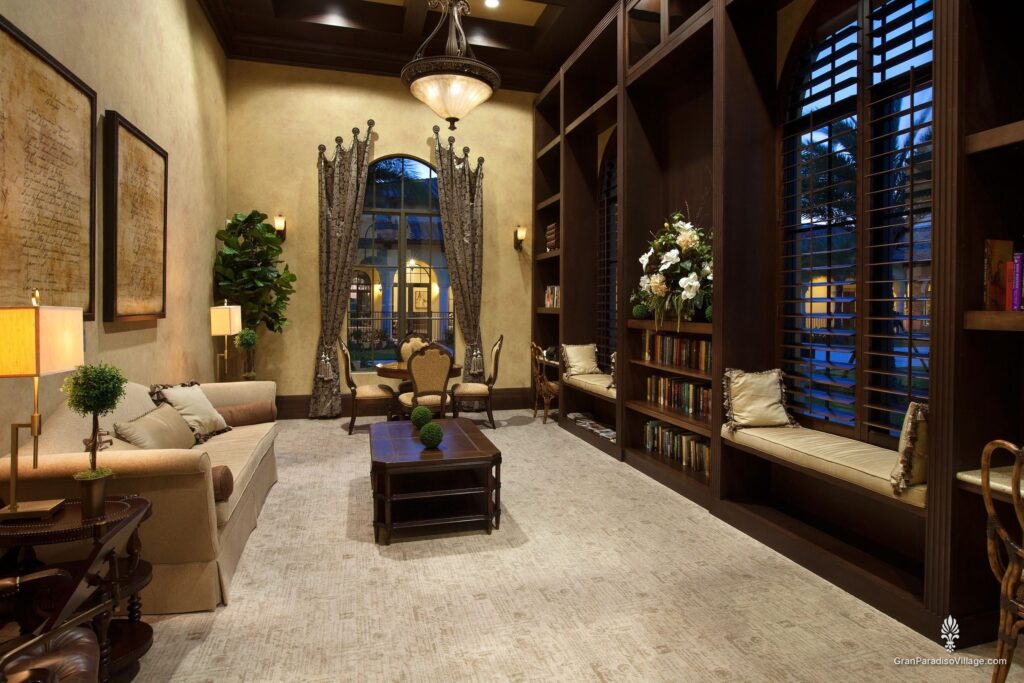 Clubhouse library with built-in bookshelves, cushioned window seats, a sofa and coffee table
