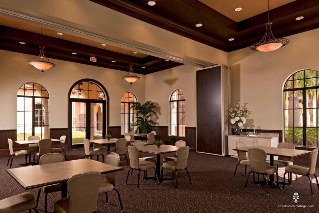 Party room with café tables, arched windows and a folding partition wall in the clubhouse