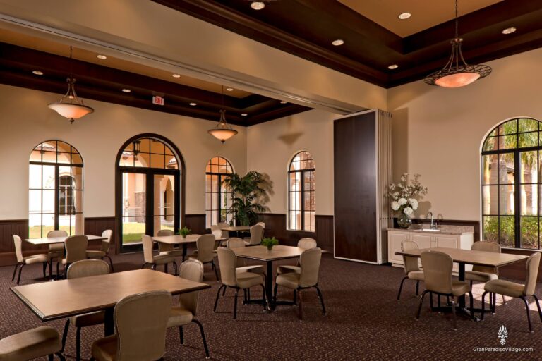 Party room with café tables, arched windows and a folding partition wall in the clubhouse