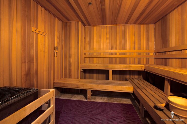 Cedar sauna with tiered wooden benches and a heater