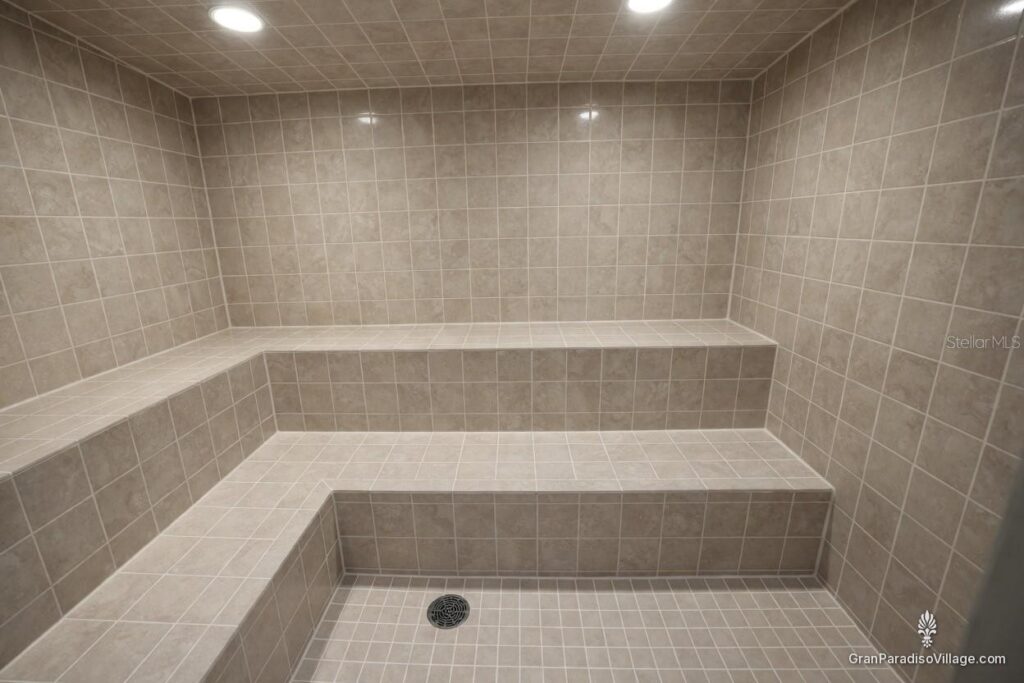 Gray tiled steam room with tiered built-in benches