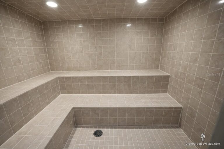 Gray tiled steam room with tiered built-in benches