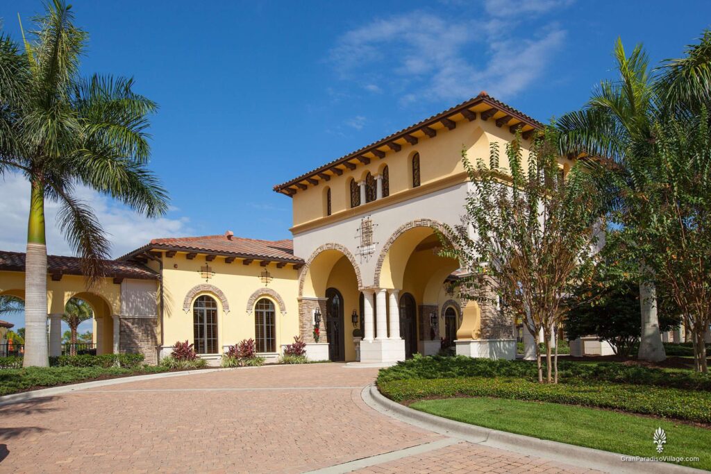 Gran Paradiso clubhouse with its arched tower entry and paver circular drive, framed by palms