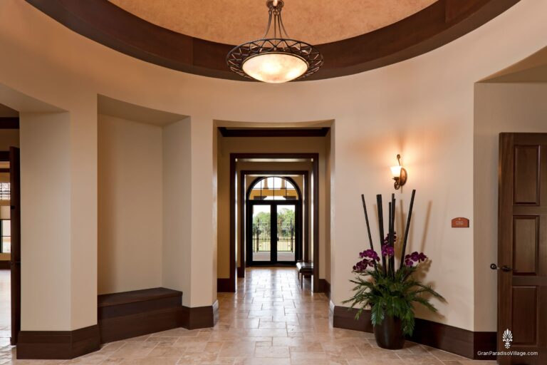 Round domed atrium with a pendant light and orchids at the fitness center entrance