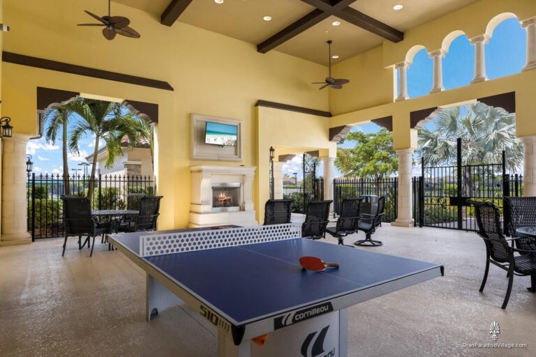 Covered outdoor lounge at Gran Paradiso with a fireplace, ping-pong table and patio seating