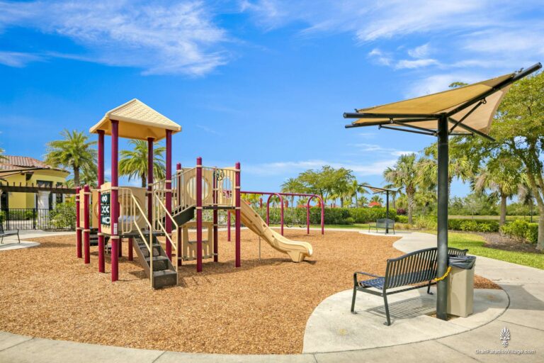 Gran Paradiso playground with a slide and swings, plus a shaded bench and palms in Wellen Park