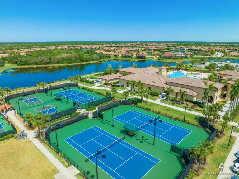 Aerial view of tennis and pickleball courts beside the clubhouse, pool and lake in Wellen Park