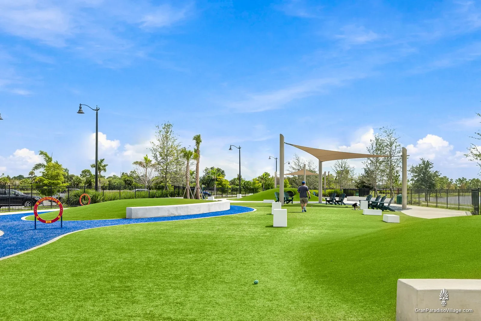 Fetch Dog Park in Wellen Park, with green turf, agility hoops, blue paths and shade sails