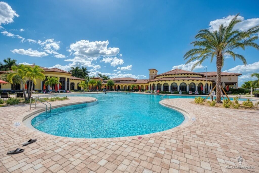 Gran Paradiso clubhouse resort pool framed by palm trees under a blue sky
