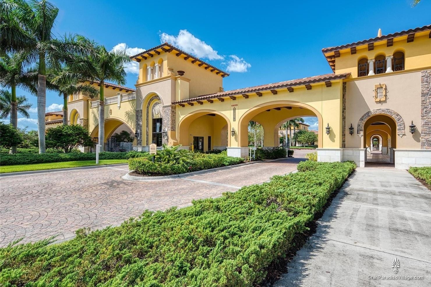 Mediterranean-style arched gatehouse with palm trees at the entrance to Gran Paradiso in Wellen Park, Florida