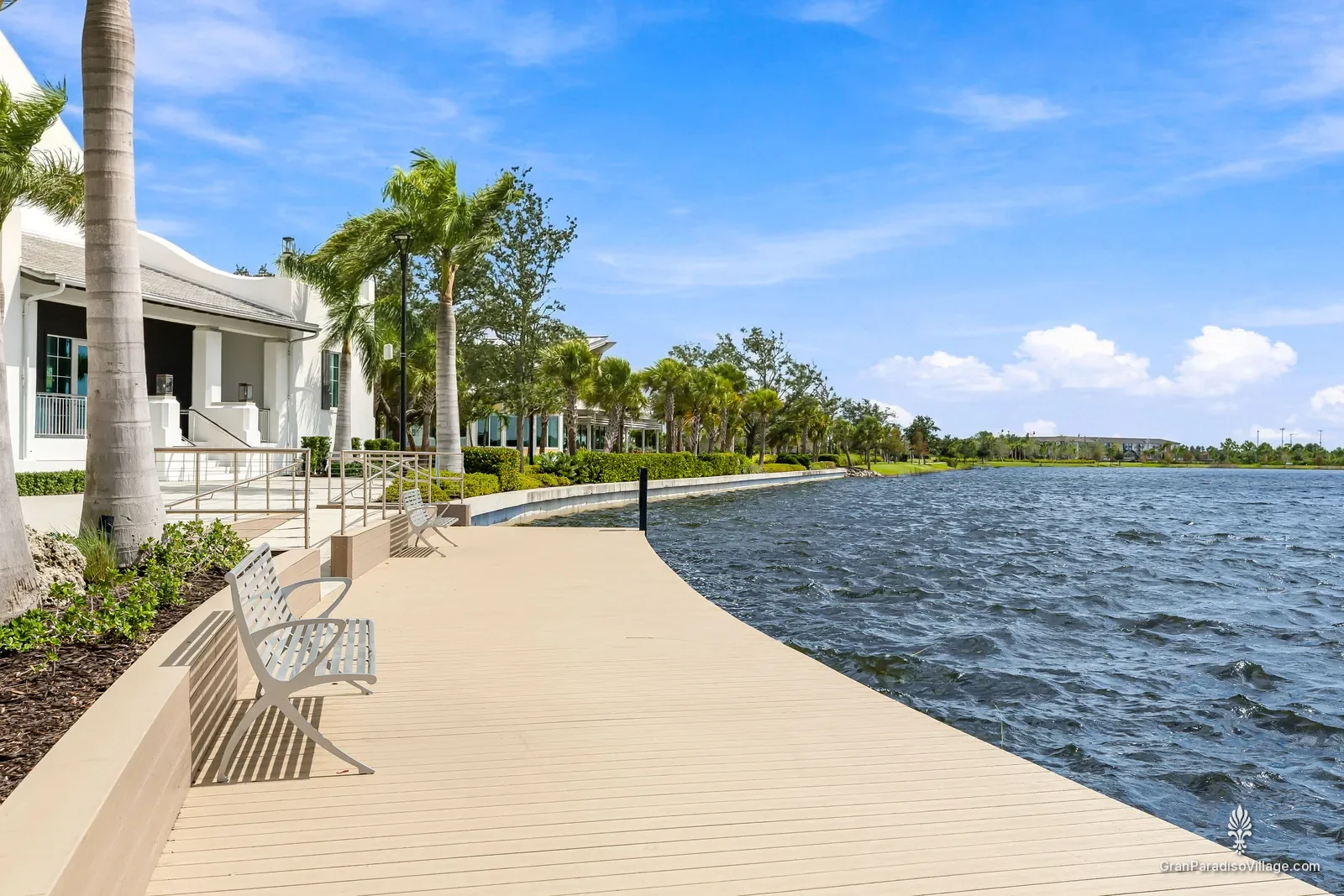Wide lakefront boardwalk with benches and palm trees along the Grand Lake in Downtown Wellen, Wellen Park